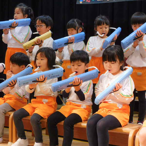 鍵盤ハーモニカを演奏する園児たち