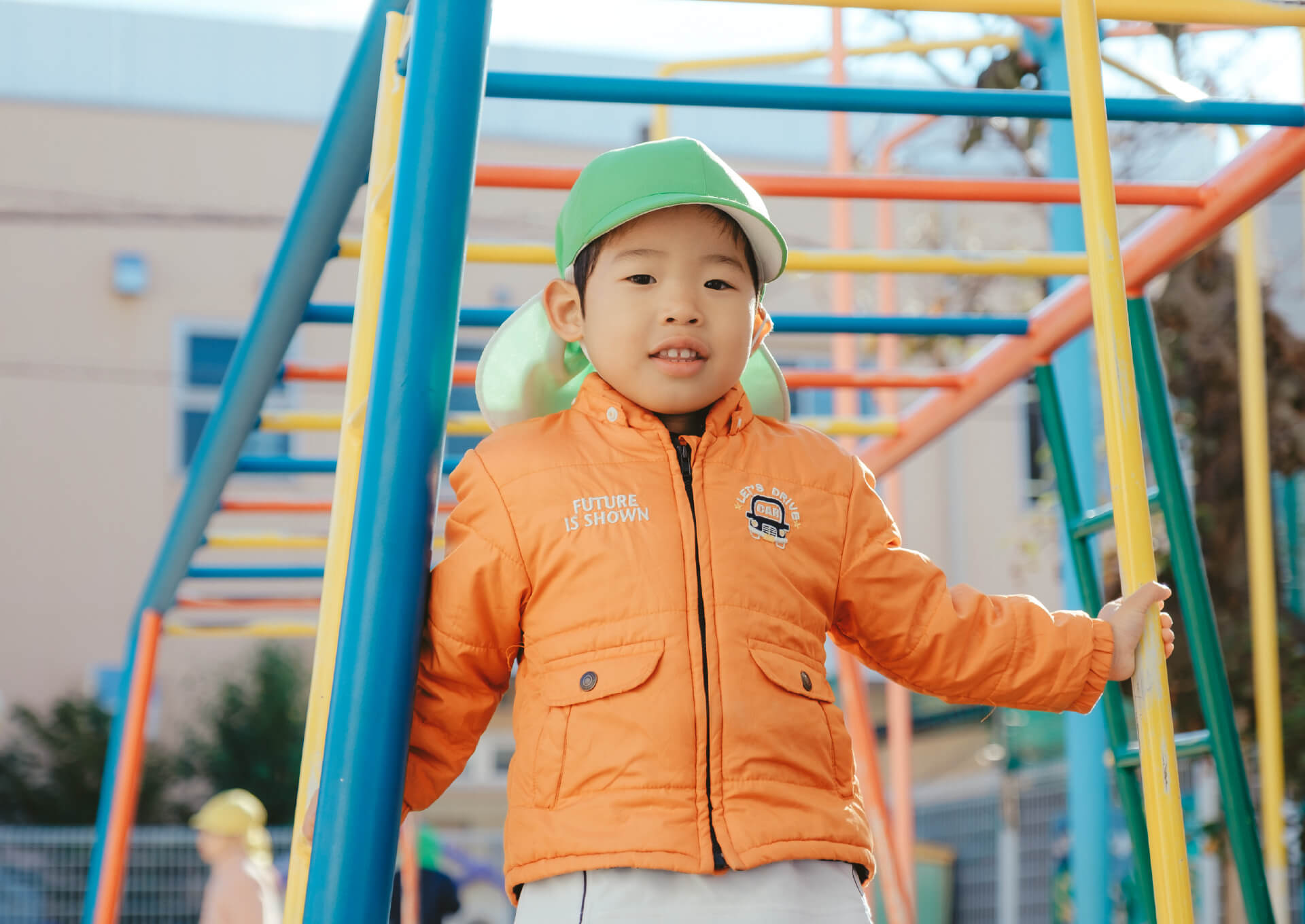 園庭のジャングルジムで遊ぶ園児