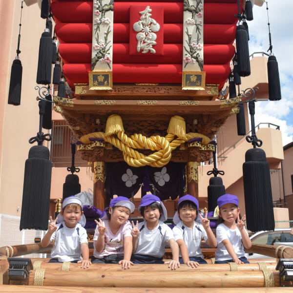 だんじりの前で記念撮影する園児たち