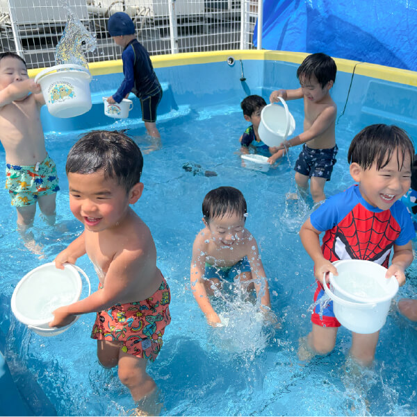 プールで水遊びを楽しむ園児たち