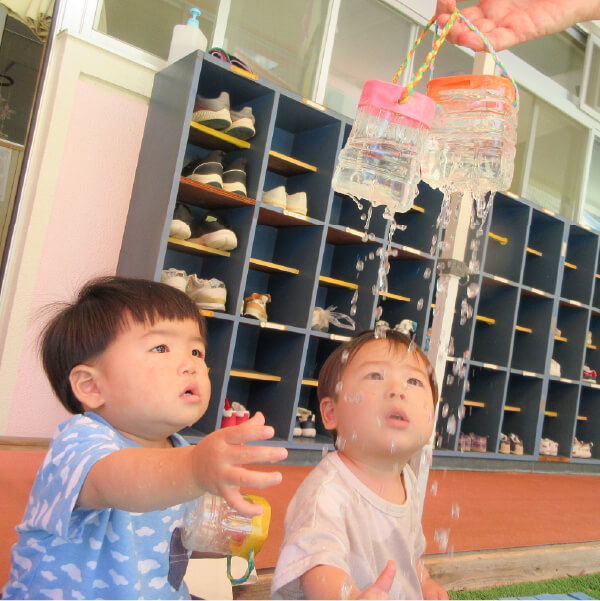 手作りおもちゃで水遊びをする園児たち
