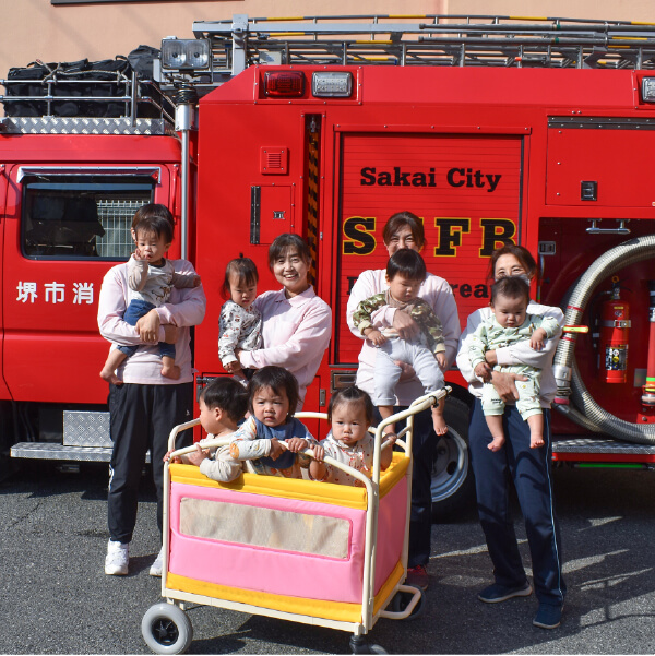 消防車の前で記念撮影する園児と先生